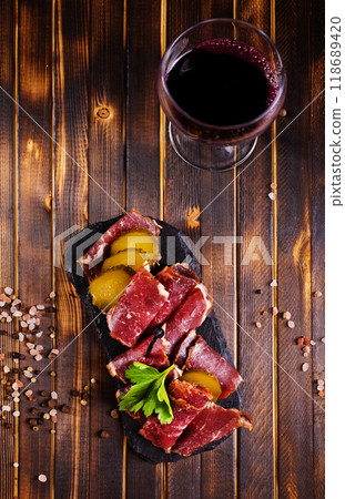 Flat slices of square sandwich ham with herbs. Dark background. Top view. Copy space. Flat slices of square sandwich ham with herbs. Dark background. Top view. Copy space. 118689420