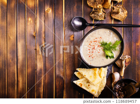 Bowl of creamy mushroom soup, sliced mushrooms and parsley with bread Bowl of creamy mushroom soup, sliced mushrooms and parsley with bread 118689457