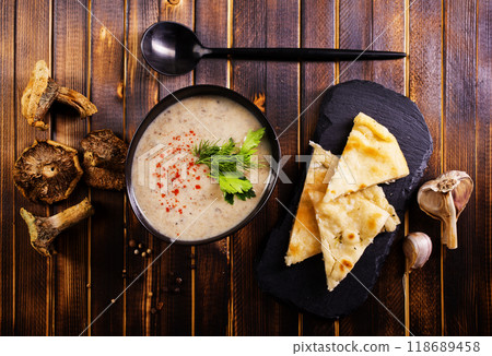 Bowl of creamy mushroom soup, sliced mushrooms and parsley with bread Bowl of creamy mushroom soup, sliced mushrooms and parsley with bread 118689458