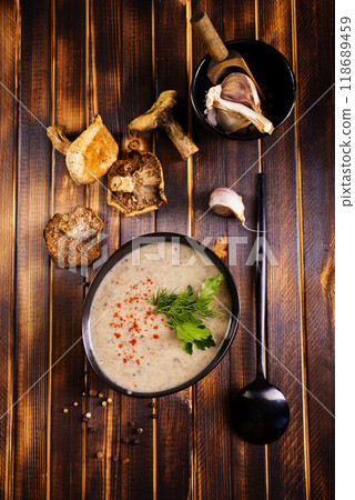 Bowl of creamy mushroom soup, sliced mushrooms and parsley with bread Bowl of creamy mushroom soup, sliced mushrooms and parsley with bread 118689459