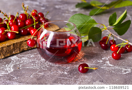 Cherry juice in a glass and fresh cherries on a table 118689521