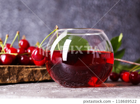 Cherry juice in a glass and fresh cherries on a table 118689522