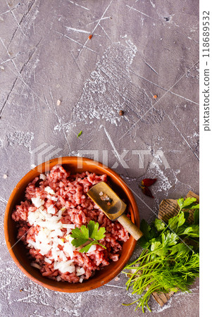 Homemade minced meat with ingredients for making in a bowl over dark slate, stone or concrete background. 118689532