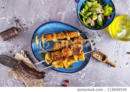 Lamb shish kebab with pieces of onion. kebab and salad on a table 118689540