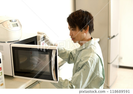A male worker who checks the microwave oven 118689591