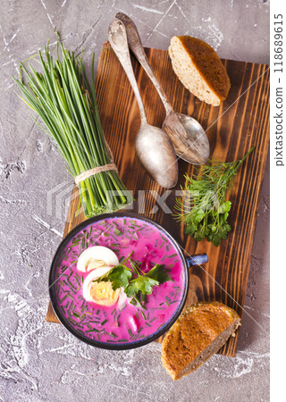 A portion of beetroot soup with egg, dill, parsley and cucumber on a gray background. 118689615