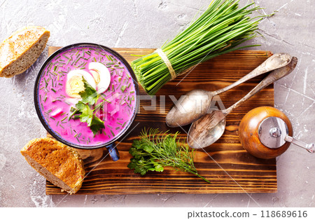 A portion of beetroot soup with egg, dill, parsley and cucumber on a gray background. 118689616