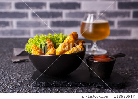 There is a plate of crispy chicken nuggets on the table. Fast food. 118689617