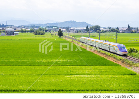 [Yamagata Line] A mini Shinkansen train running through a rural landscape 118689705