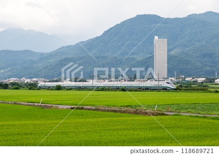 [Yamagata Line] A mini Shinkansen train running through a rural landscape 118689721