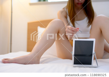 A young woman taking care of her VIO delicate zone crotch area herself, tweezing hair with tweezers while looking in the mirror, real color A young woman taking care of her VIO delicate zone crotch area herself, tweezing hair with tweezers while looking in the mirror, real color 118690325