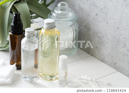 Cosmetic bottles and accessories lined up on white tiles Cosmetic bottles and accessories lined up on white tiles 118691424