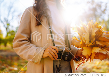 Woman taking pictures in autumn forest. Smiling woman enjoying autumn weather. Lifestyle concept. Woman taking pictures in autumn forest. Smiling woman enjoying autumn weather. Lifestyle concept. 118691832