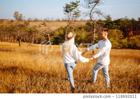 Young couple having fun walking and hugging n the park. Autumn weather. Relaxation, youth. 118692011