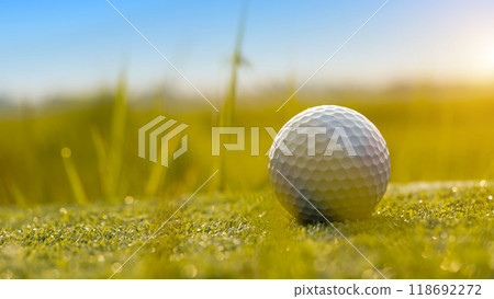 Golf ball is on a green lawn in a beautiful golf course with morning sunshine. 118692272