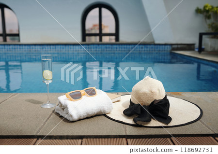 Arranging Poolside Accessories Including Hat and Sunglasses 118692731