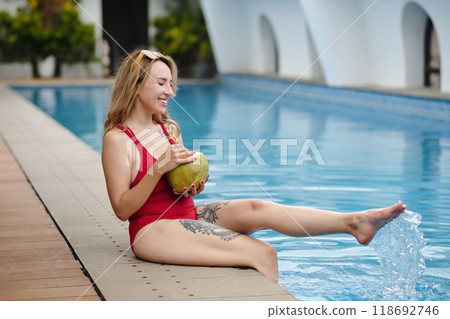 Relaxing by Poolside Holding Fresh Coconut Drink Relaxing by Poolside Holding Fresh Coconut Drink 118692746