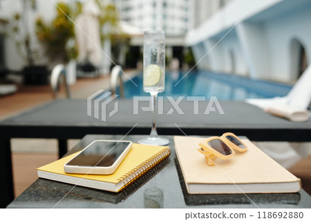 Refreshing Poolside Setup with Drink and Accessories Refreshing Poolside Setup with Drink and Accessories 118692880