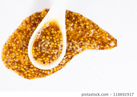 Traditional French Dijon mustard in a spoon on a white background Traditional French Dijon mustard in a spoon on a white background 118692917