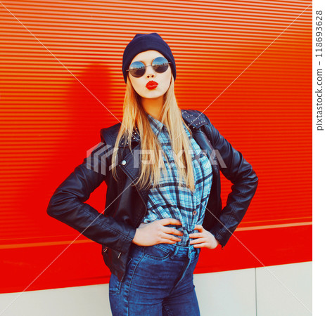 Fashion portrait beautiful blonde woman sends air kiss blowing red lips outdoors wearing sunglasses and black hat 118693628