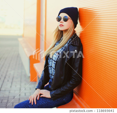 Fashion portrait pretty blonde woman in rock black style on a colorful orange background 118693641