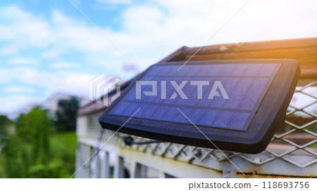 Close up small solar panel designed to power decorative lights along a balcony. The image highlights the compact solar cells, showcasing their functionality eco-friendly energy use. Close up small solar panel designed to power decorative lights along a balcony. The image highlights the compact solar cells, showcasing their functionality eco-friendly energy use. 118693756