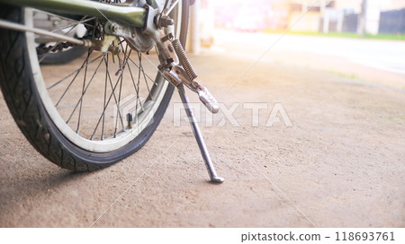 Wheel of a bicycle is flat parking on concrete sidewalk beside a road, need to be repaired, the moment of stillness and an unexpected pause in a journey. 118693761