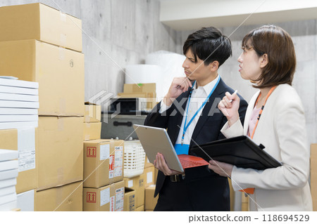 Employee checking goods in the warehouse 118694529