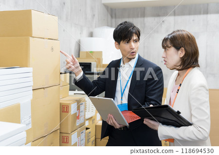 Employee checking goods in the warehouse 118694530