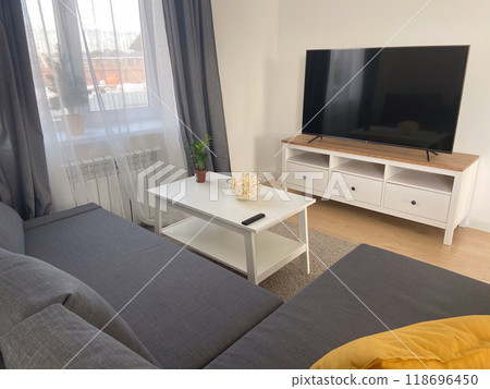 Scandinavian living room with sleek furniture and a cozy atmosphere. Sunlight casts gentle shadows warm ambiance. Scandinavian living room with sleek furniture and a cozy atmosphere. Sunlight casts gentle shadows warm ambiance. 118696450