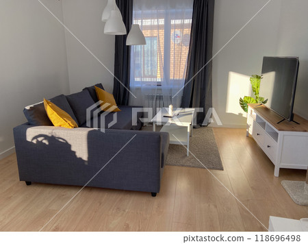 Scandinavian living room with sleek furniture and a cozy atmosphere. Sunlight casts gentle shadows warm ambiance. Scandinavian living room with sleek furniture and a cozy atmosphere. Sunlight casts gentle shadows warm ambiance. 118696498