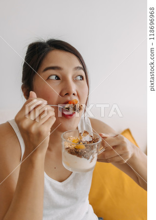Happy woman eating healthy homemade snack made of yogurt. 118696968