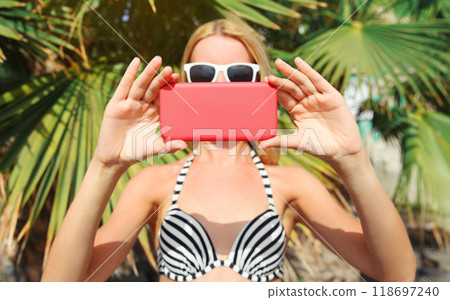 Summer portrait close up woman taking selfie picture with phone on the beach, palm tree background Summer portrait close up woman taking selfie picture with phone on the beach, palm tree background 118697240
