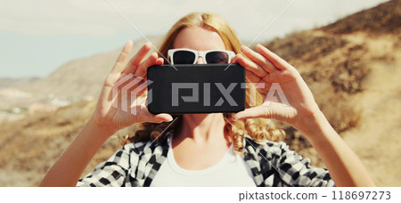 woman taking selfie with phone on hiking trail on top of mountain, Tenerife, Canary Islands, Spain woman taking selfie with phone on hiking trail on top of mountain, Tenerife, Canary Islands, Spain 118697273