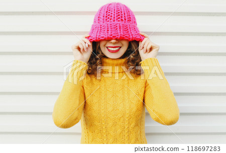 Fashion portrait happy young smiling woman wearing colorful pink knitted hat over white background 118697283