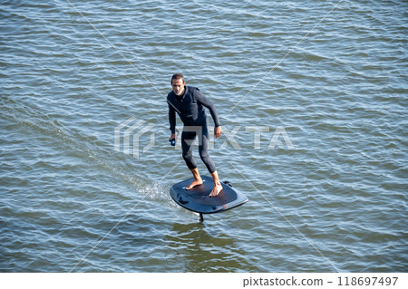 Silhouetted man on a hydrofoil surfboard 118697497