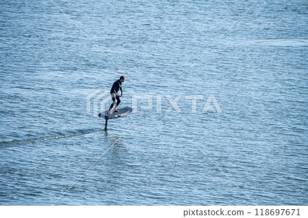 Silhouetted man on a hydrofoil surfboard Silhouetted man on a hydrofoil surfboard 118697671