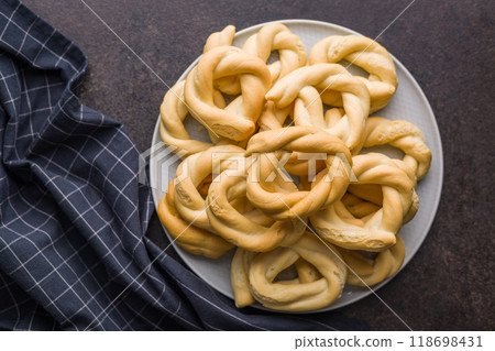 Ciambelle di pane. Crispy italian salted donuts on plate on black table. Top view. Ciambelle di pane. Crispy italian salted donuts on plate on black table. Top view. 118698431