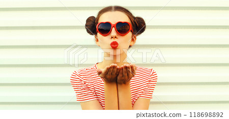 Portrait stylish young woman blowing kiss with red lipstick with cool hairstyle on white background Portrait stylish young woman blowing kiss with red lipstick with cool hairstyle on white background 118698892