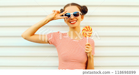 Summer portrait of happy smiling young woman with lollipop on white background Summer portrait of happy smiling young woman with lollipop on white background 118698899