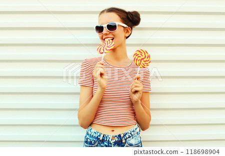 Summer portrait of happy smiling young woman with lollipop on white background 118698904