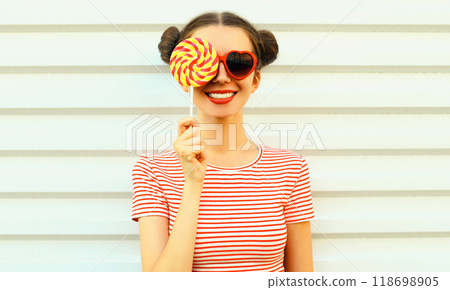 Summer portrait of happy smiling young woman with lollipop on white background 118698905