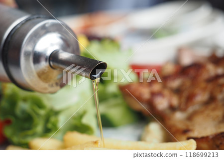 Healthy Salad Prep with Olive Oil in a Cozy Restaurant. Enjoy a fresh and wholesome meal Healthy Salad Prep with Olive Oil in a Cozy Restaurant. Enjoy a fresh and wholesome meal 118699213