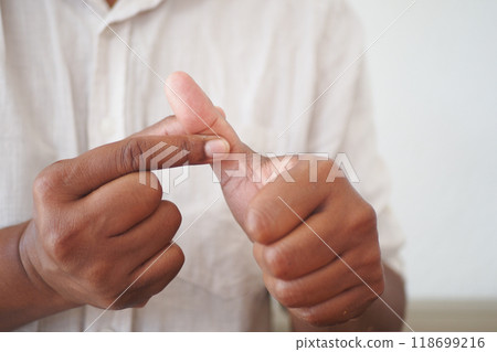 man suffering pain in his thumb finger man suffering pain in his thumb finger 118699216