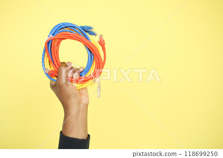 A closeup of hands holding coiled Ethernet cables for a network connection A closeup of hands holding coiled Ethernet cables for a network connection 118699250