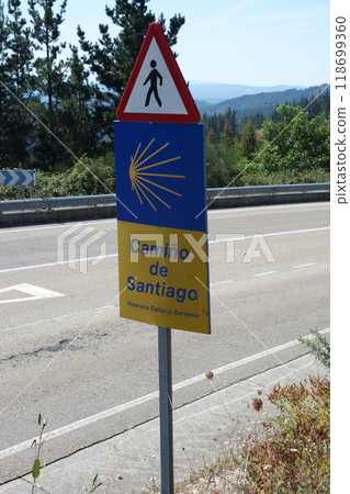 Signpost of the Saint James Way displaying the traditional yellow arrow and scallop Signpost of the Saint James Way displaying the traditional yellow arrow and scallop 118699360