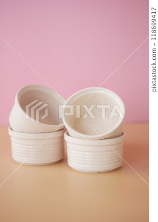A lovely composition of stacked white ceramics beautifully placed on a soft pink background 118699417