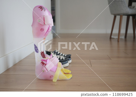 child legs orthosis and shoes on a wooden floor child legs orthosis and shoes on a wooden floor 118699425