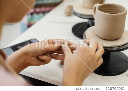 Creating pottery by hand during a pottery class in a studio setting 118700081