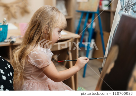 Child painting on an easel in a creative art classroom setting 118700083